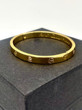 Close-up of a gold Cartier-inspired bangle bracelet with artificial diamonds, designed for an elegant look.