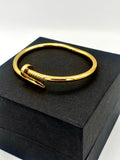 Elegant gold bangle bracelet with a simple yet sophisticated clasp detail.