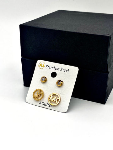 Close-up of two pairs of gold stud earrings, one with a crystal accent and the other with a sleek gold design.