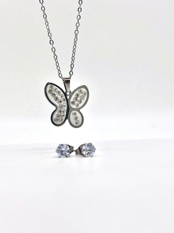 Close-up view of a silver butterfly necklace with crystal accents and matching stud earrings.