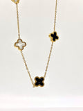 Elegant gold necklace with clover-shaped black and white enamel accents.