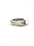 Close-up of a sleek stainless steel stackable ring set with geometric shapes.